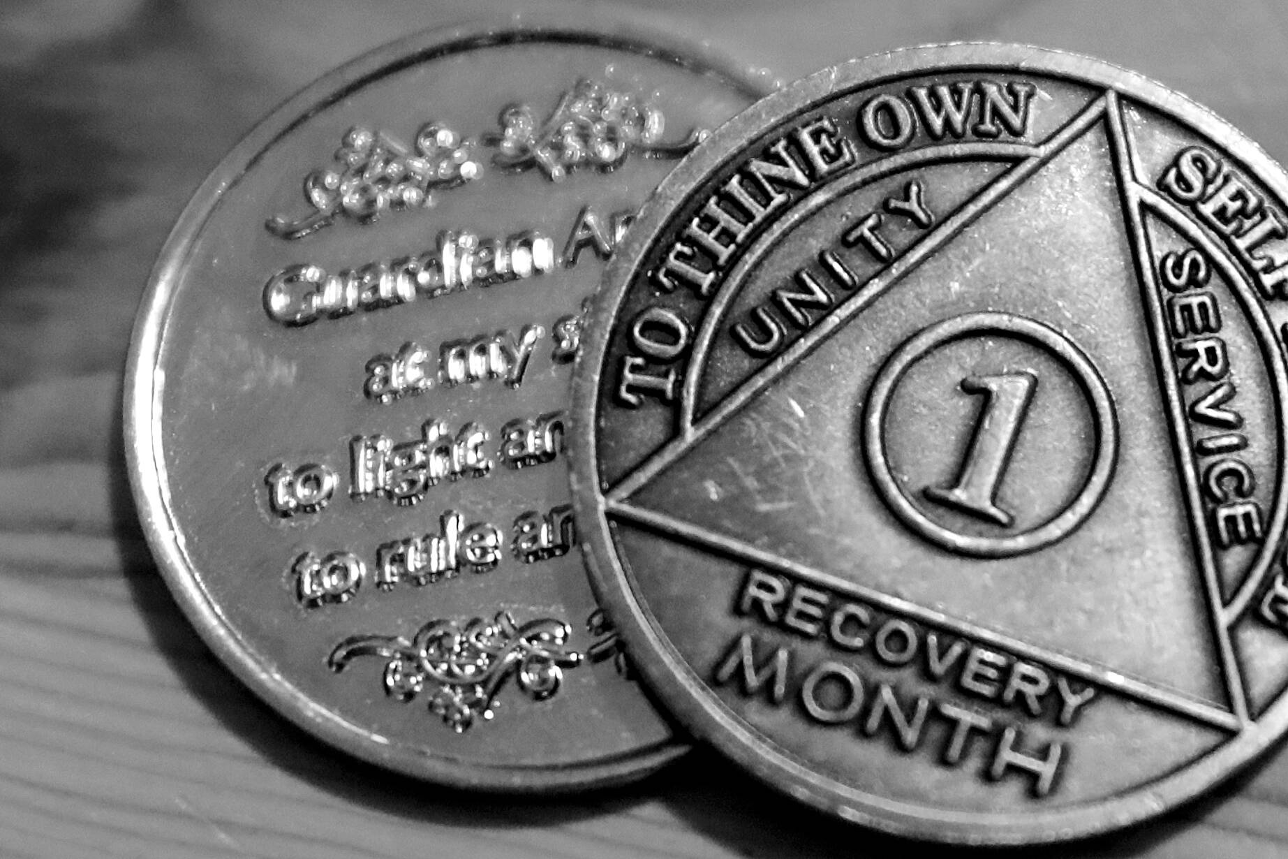 One person’s month recovery coins after battling a fentanyl addiction. (Kevin Clark / The Herald)