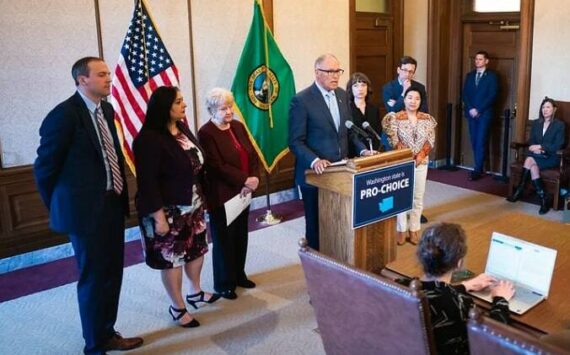 From left to right: Rep. Marcus Riccelli, Sen. Manka Dhingra, Sen. Karen Keiser, Gov. Jay Inslee, Rep. Jessica Bateman, Rep. My-Linh Thai and AG Bob Ferguson. (Courtesy photo)