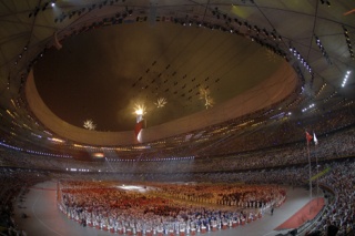 The Olympic Torch blazes during the Opening Ceremony in Bejing. Local photographers Serge and Amy Timacheff are taking pictures of official fencing competitions.