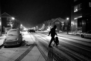 A man crosses the street on a snowy night last nigh in the Issaquah Highlands. A spring storm coated cars and streets as well as caused minor problems for drivers recently.