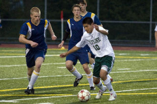 Skyline’s Edgar Esquivel attempts to maneuver the ball around a group of Bainbridge defenders Saturday night.