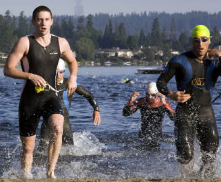 Competitors sprint from the water en route to the bicycle transition area during last Saturday’s Issaquah Triathlon.