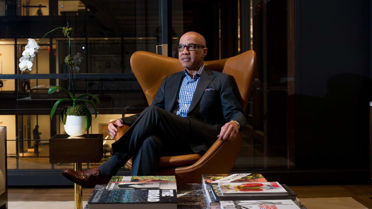 Darren Walker sitting on a leather chair in his office. 